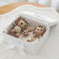 Crocheted lion baby toys and teething ring in a white gift box with gold dots
