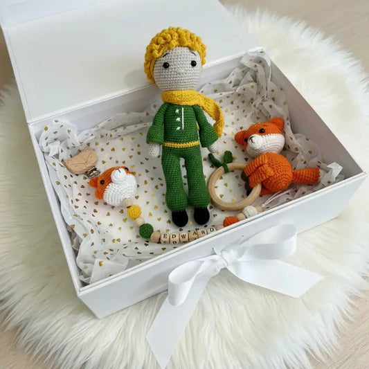 Crocheted dolls and toys in a white gift box with personalized name blocks