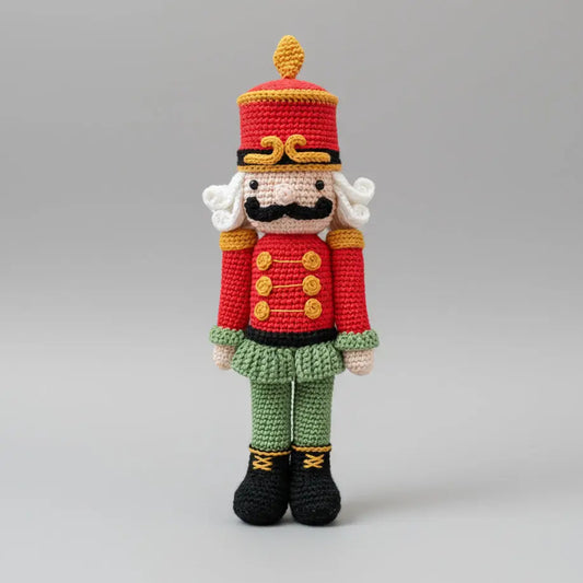 Crocheted nutcracker soldier in red, green, and yellow, with curly white hair