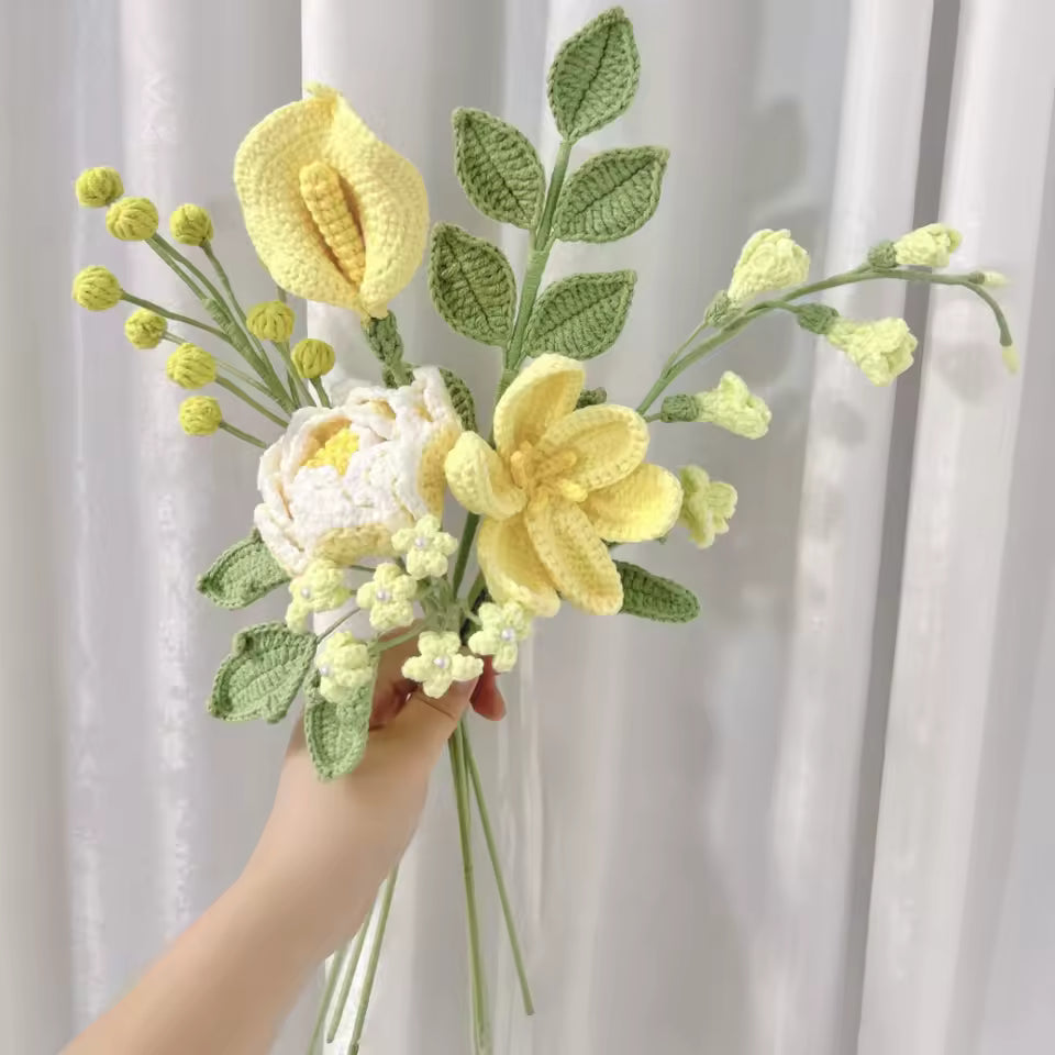 Crocheted bouquet with yellow and white flowers, green leaves, held by a hand