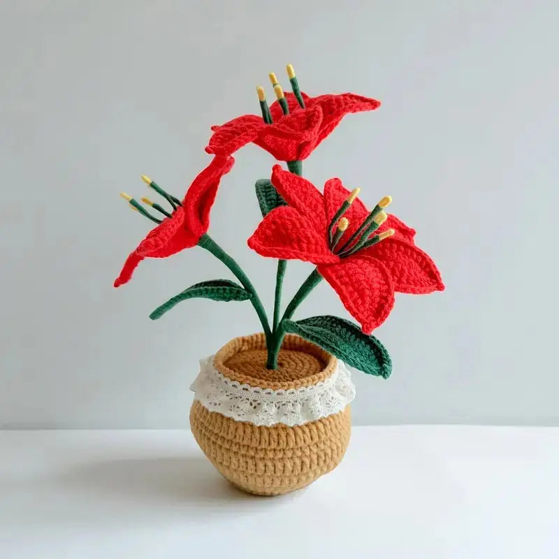 Crocheted red lilies with yellow stamens in a textured beige and lace-trimmed pot