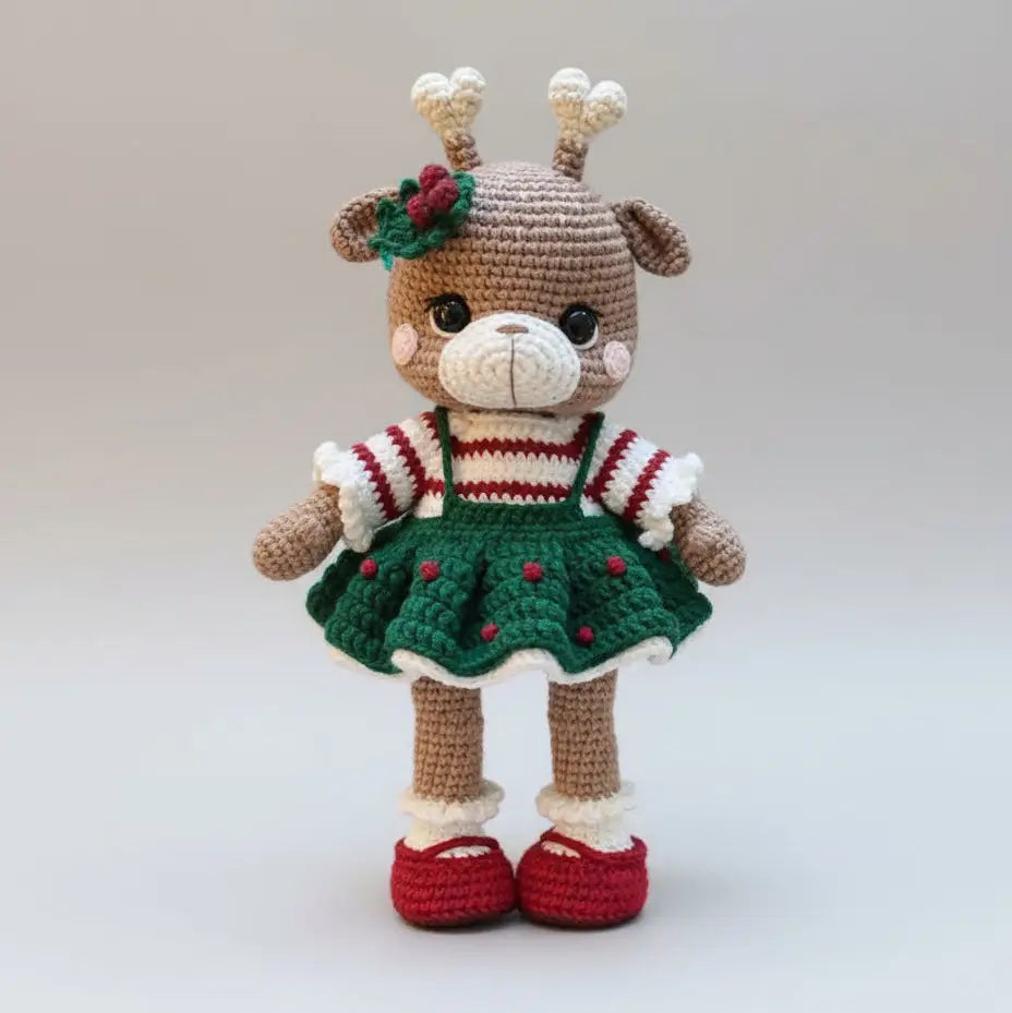 Crocheted reindeer doll in festive green dress with red holiday accents