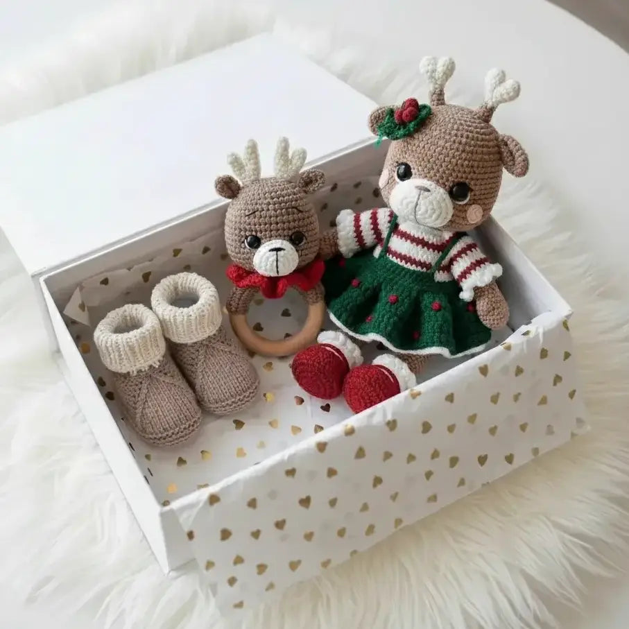 Two crocheted deer toys in a decorative box on a white surface