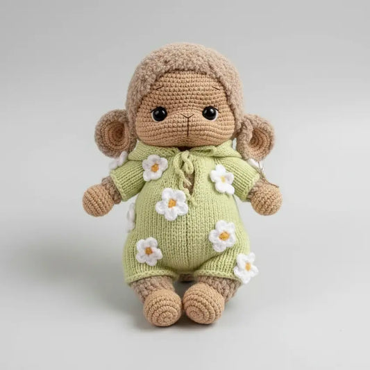 Crocheted lamb toy in green outfit with white flower details, sitting cutely