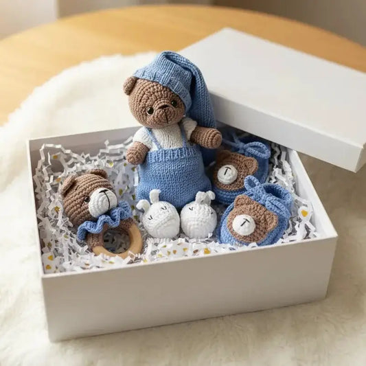 Handmade knitted teddy bear and baby accessories in blue and white gift box