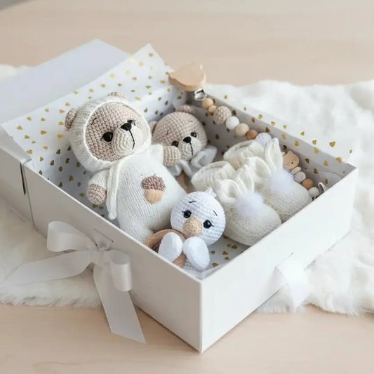 Crocheted stuffed animals nestled in a white gift box with gold hearts and ribbon