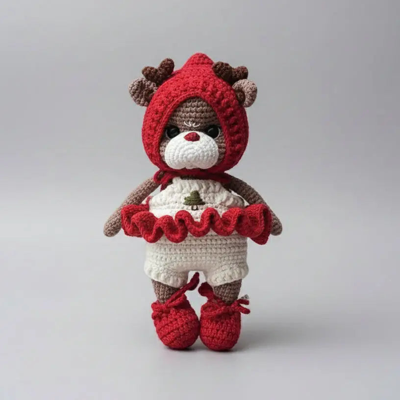 Crocheted teddy bear in red winter outfit with deer antlers and ruffled collar