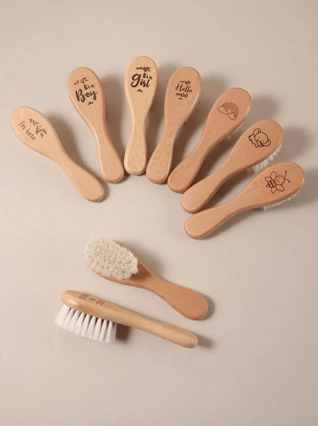 Wooden baby brushes with engraved phrases and cute icons, arranged in a fan shape