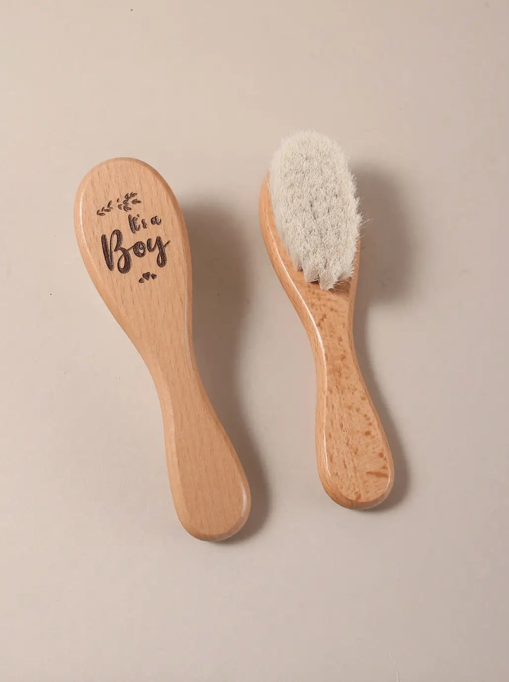 Wooden baby brush and comb set with "It's a Boy" engraving on light background