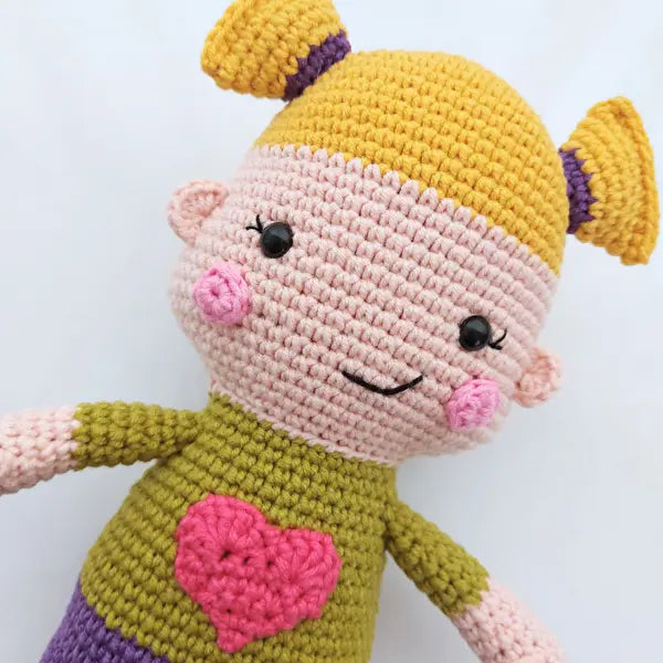 a crocheted doll with a heart on it