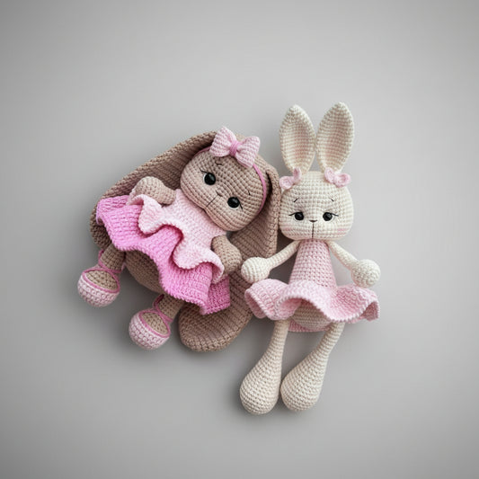 Two crocheted bunny dolls in pink and brown with frilly skirts against a gray background.