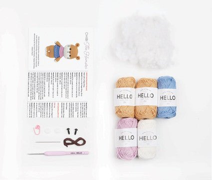 Knitting yarn skeins in beige, pink, and blue with "HELLO" labels on white background