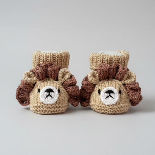 Knitted baby booties shaped like adorable lions, with brown mane and tan body