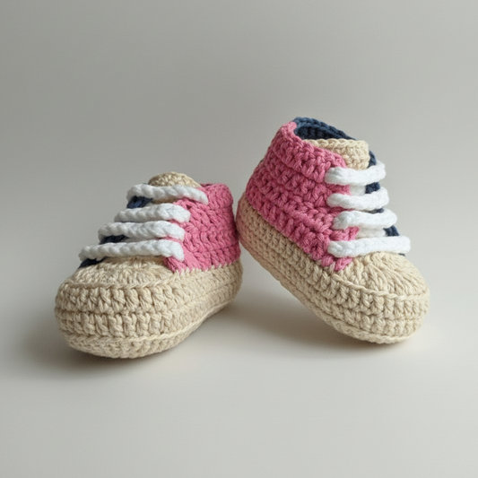 Handmade crocheted baby sneakers in cream, pink, and navy blue colors