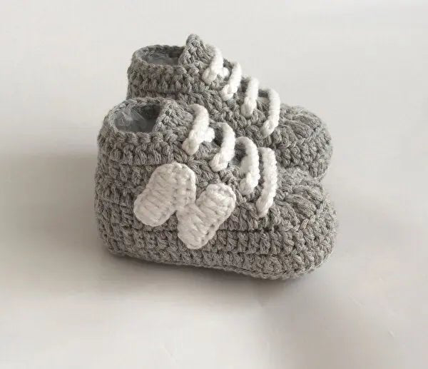 Gray crocheted baby booties with white laces, soft and cozy newborn shoes
