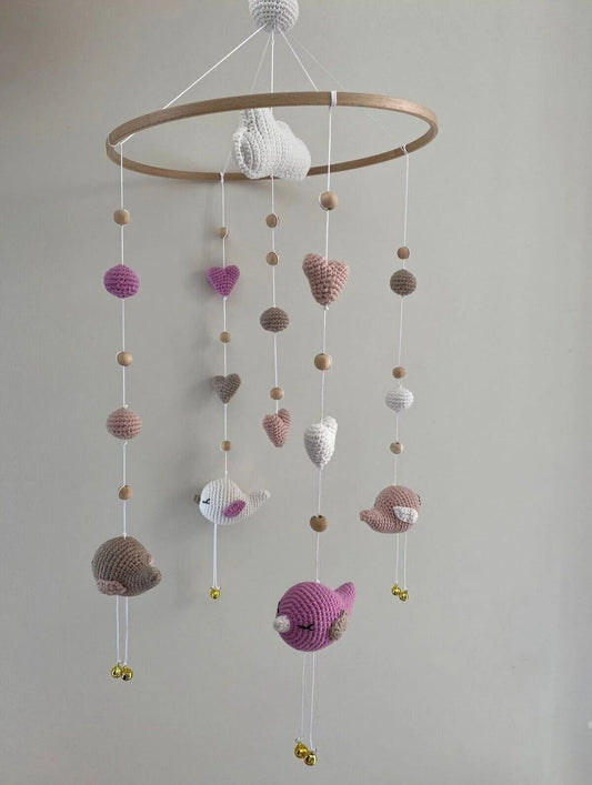 Crocheted baby mobile with hearts, birds, and wooden beads in pastel colors
