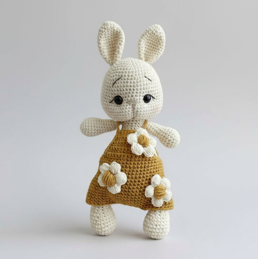 Crocheted white bunny wearing mustard dress with white flower appliques
