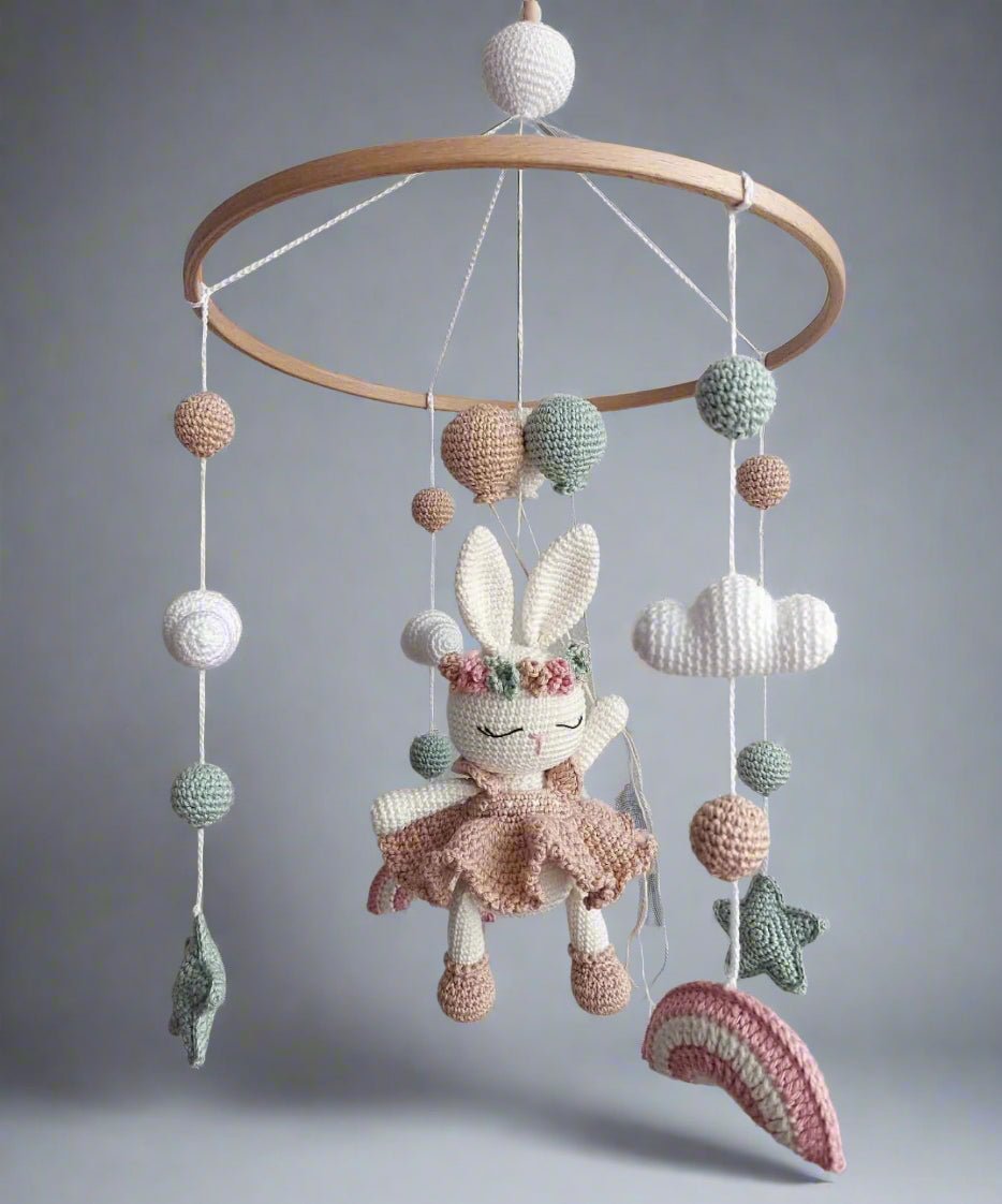 Crocheted baby mobile with bunny, clouds, balls, and stars in pastel colors