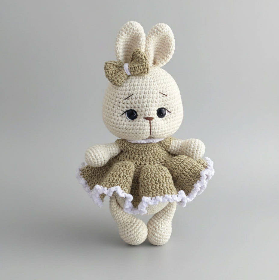 Crocheted bunny doll with bow, wearing a ruffled olive green and white dress