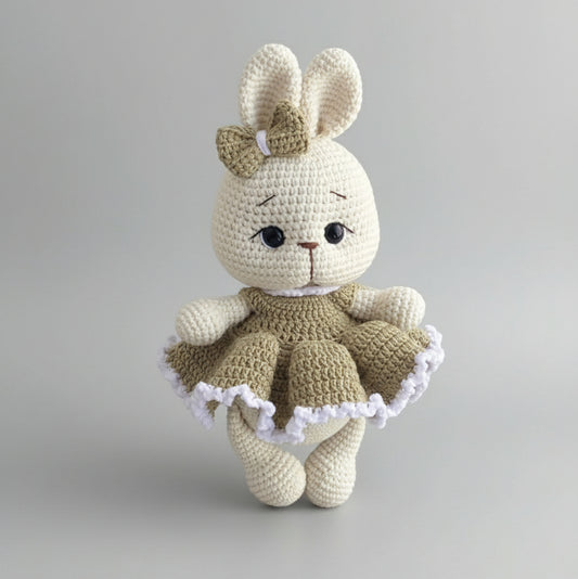 Crocheted bunny doll with bow, wearing a ruffled olive green and white dress