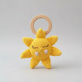 Crocheted yellow sun-shaped baby teether with wooden ring, cute sleepy face design