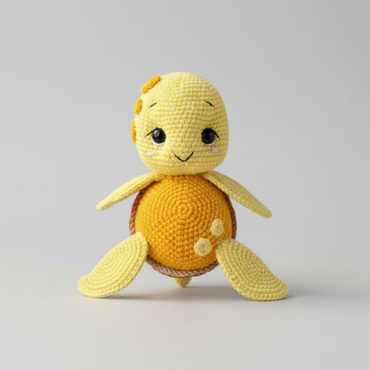 Crocheted yellow turtle stuffed animal with cute smiling face on gray background