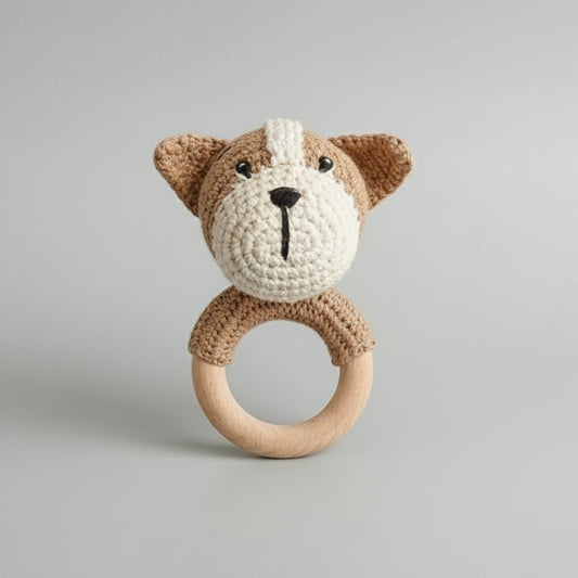 Crocheted teddy bear rattle with wooden teething ring on neutral background