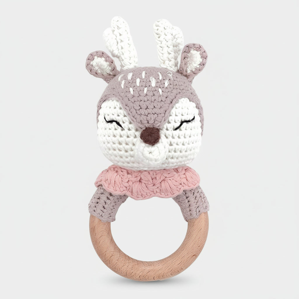 Crocheted deer baby rattle with wooden ring in soft gray, white, and pink colors