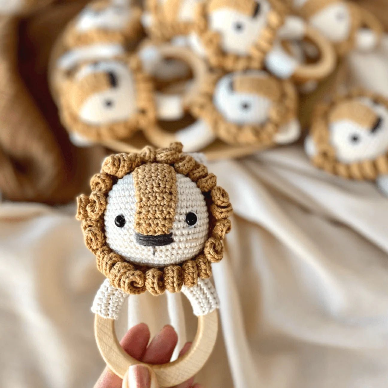 Crocheted lion baby teething ring with wooden circle and cute smiling face