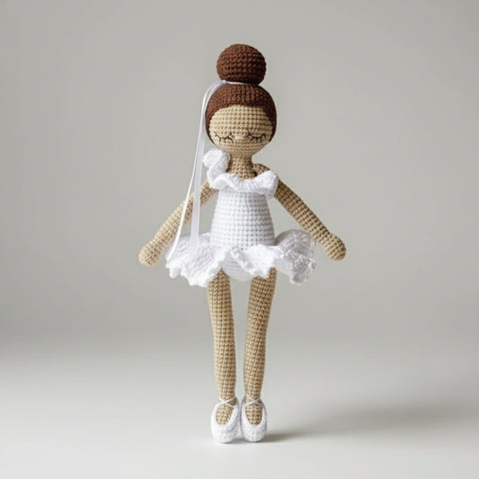 Crocheted ballerina doll with white tutu and bun hairstyle in soft beige and white yarn