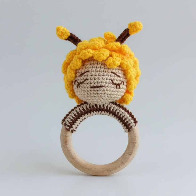 Crocheted bee baby rattle with wooden ring, yellow and brown yarn colors
