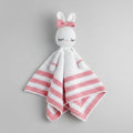 Crocheted bunny lovey with pink and white stripes, closed eyes, and a bow