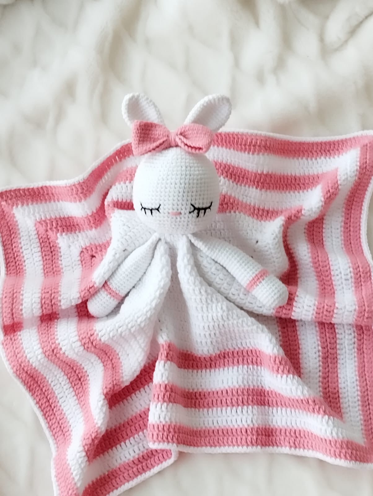 Crocheted bunny lovey with pink and white striped blanket, cute sleepy eyes and bow
