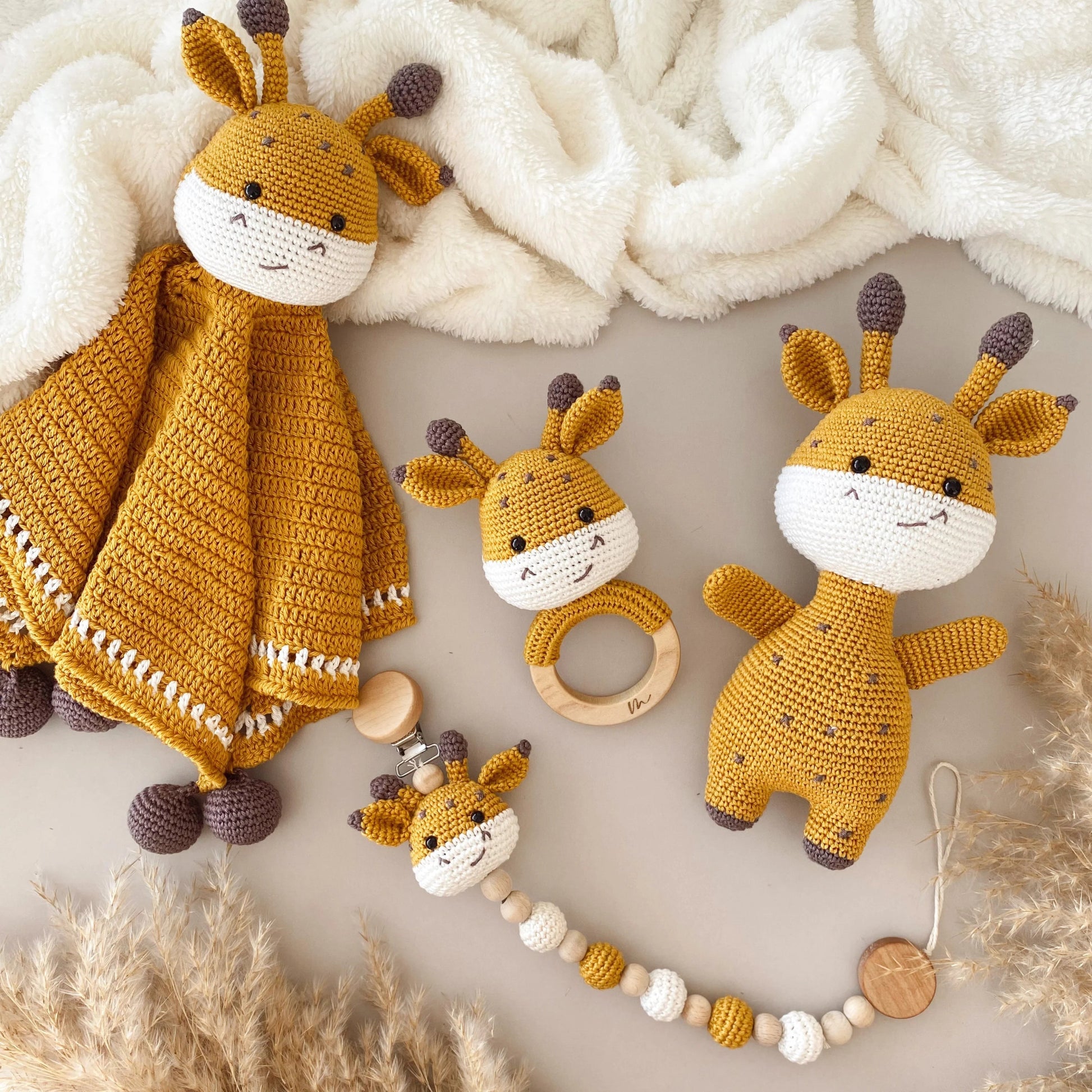 Handmade crochet giraffe toys in mustard and white, with teething ring and comfort blanket.