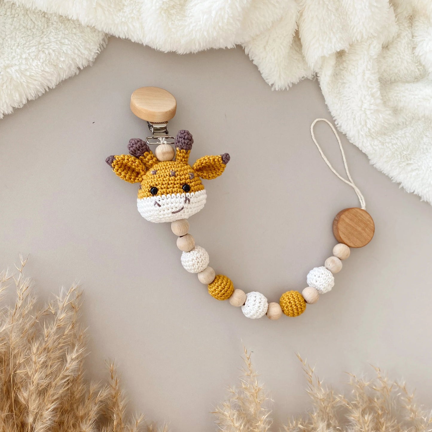 Crocheted giraffe baby pacifier clip with wooden beads, yellow and white colors