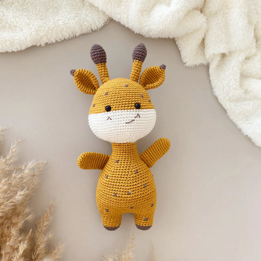 Crocheted yellow and white giraffe plush toy with cute smiling face and brown-tipped ears