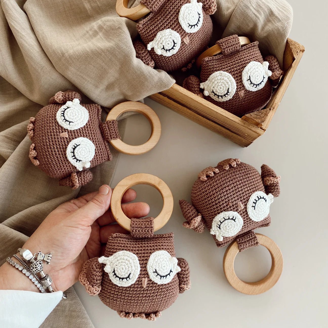 Crocheted brown owl baby rattles with white sleepy eyes and wooden rings