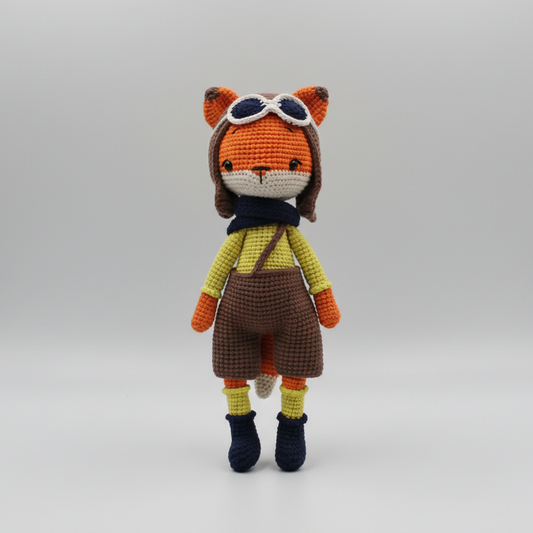Crocheted fox doll in pilot outfit with goggles, yellow shirt, and brown overalls