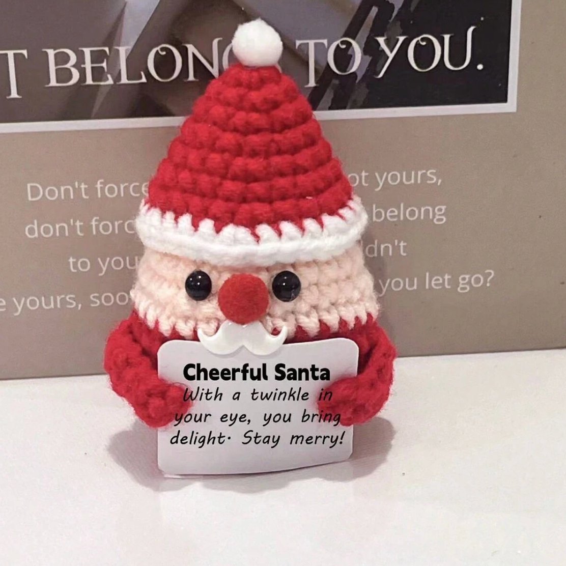 Crocheted Santa figurine with red hat, holding a "Cheerful Santa" inspirational card