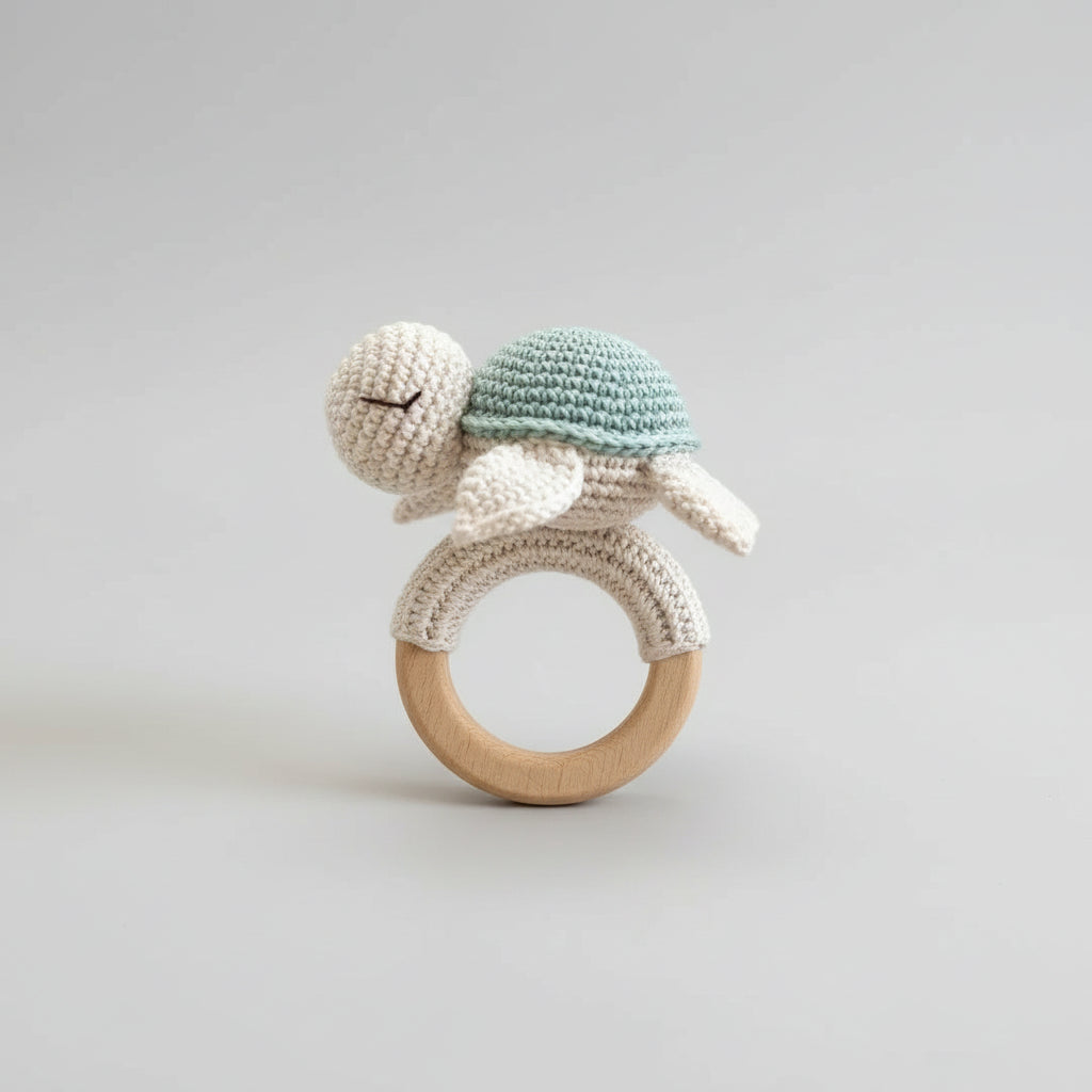 Crocheted turtle rattle on wooden teething ring with soft blue and cream colors