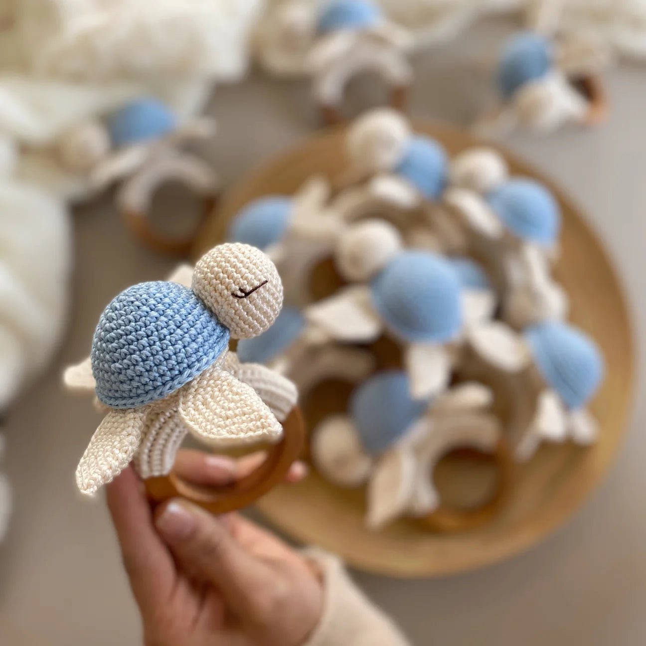 Crocheted blue and white flower teething ring for baby, handmade with wooden base
