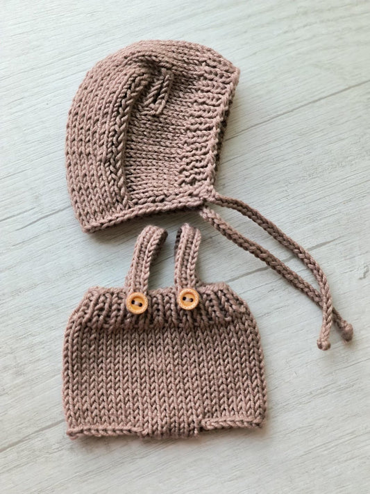 Dusty rose knitted baby bonnet and bloomers with wooden buttons on light background
