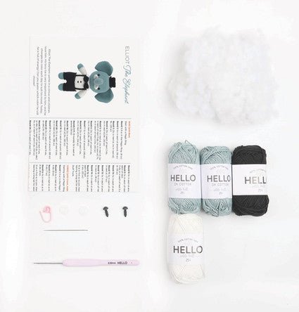 Knitting project layout with four skeins of yarn in blue, white, and black, labeled "HELLO"