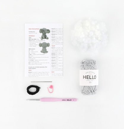 Knitting supplies laid out with pattern, yarn, crochet hook, and elephant illustrations