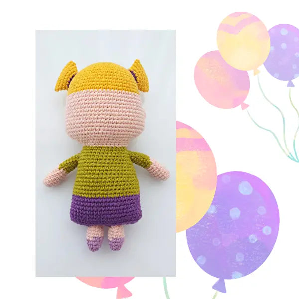 a crocheted stuffed animal with balloons in the background