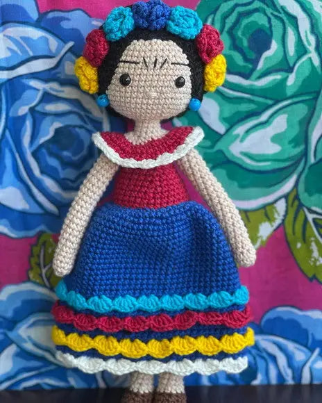 a crocheted doll is standing on a table