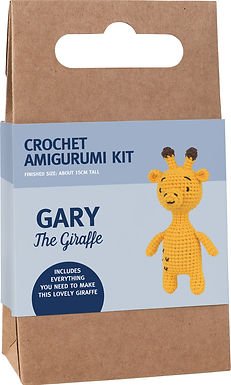 Yellow crochet giraffe amigurumi kit in packaging with craft paper background