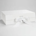 White gift box with elegant white ribbon bow, closed and pristine