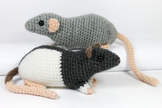 Two crocheted rats in gray and white, one solid gray and one black and white