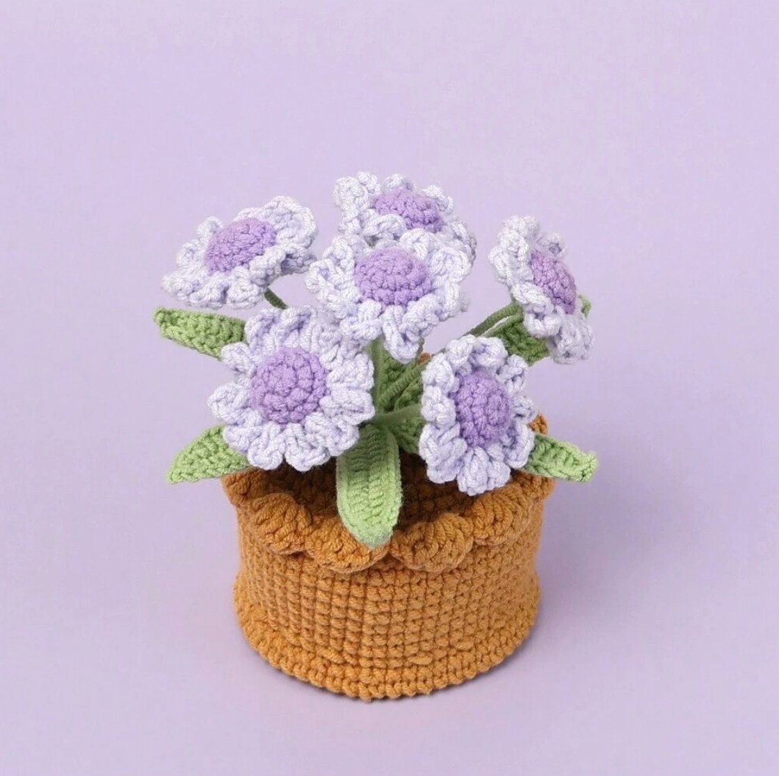 Crocheted purple and white flowers in a golden-brown textured yarn basket
